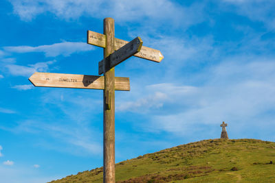 Low angle view of cross sign against blue sky