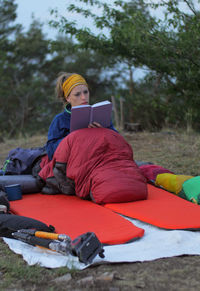 Man using mobile phone while sitting on field