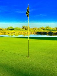 Scenic view of green grass against blue sky