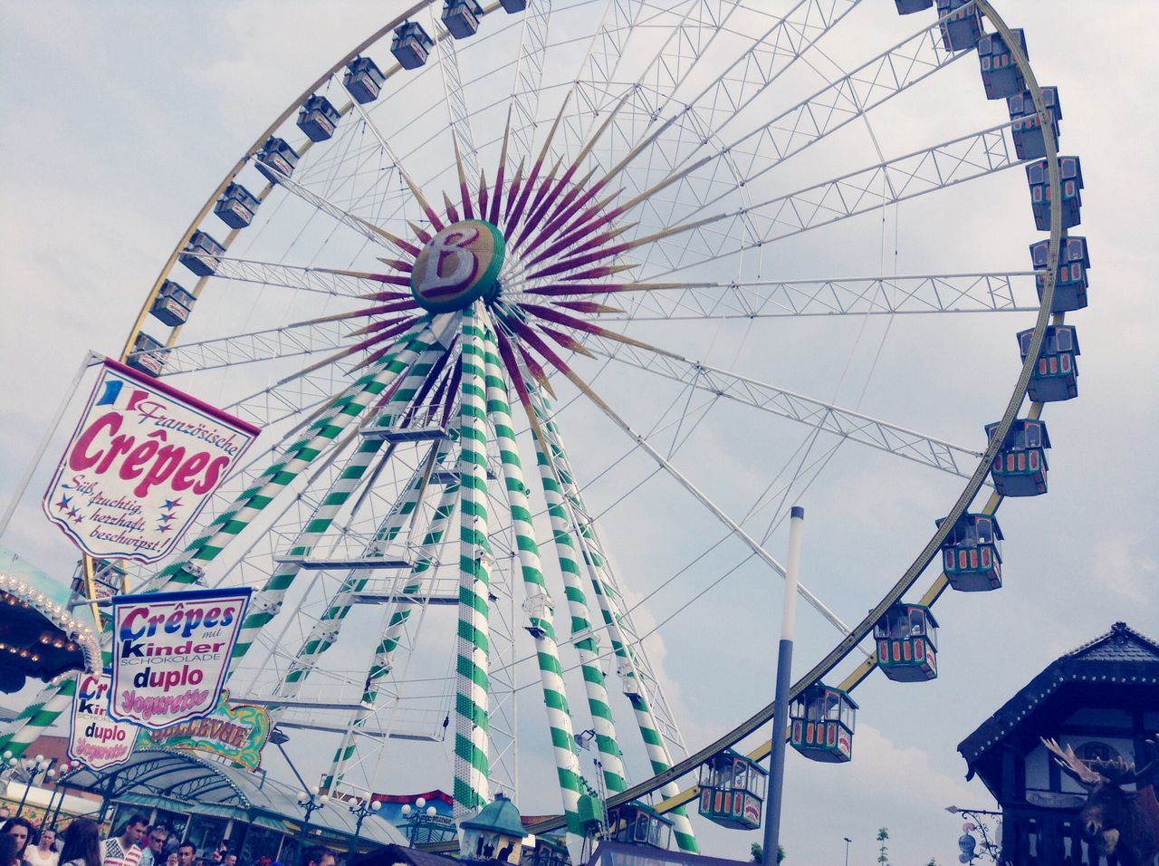 amusement park, ferris wheel, amusement park ride, low angle view, arts culture and entertainment, architecture, built structure, sky, building exterior, day, fun, outdoors, multi colored, travel destinations, city, no people, incidental people, famous place, cloud - sky, tourism