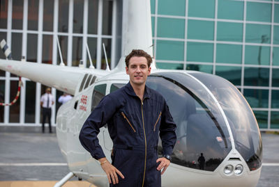 Portrait of man standing against helicopter