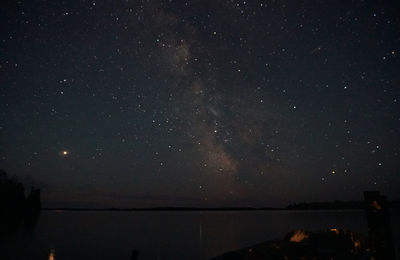 Scenic view of lake against sky at night