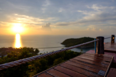 Close-up of rope against sea during sunset