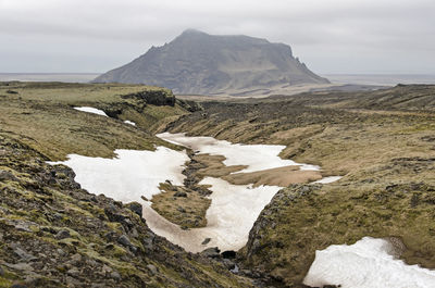 Valley in the mountains above skogar in iceland, with patches of snow