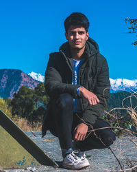 Portrait of young man sitting on mountain