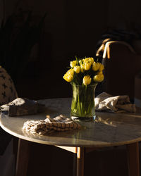 Flower vase on a round marble table during golden hour