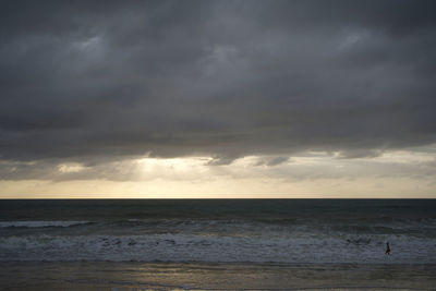 Scenic view of sea against storm clouds