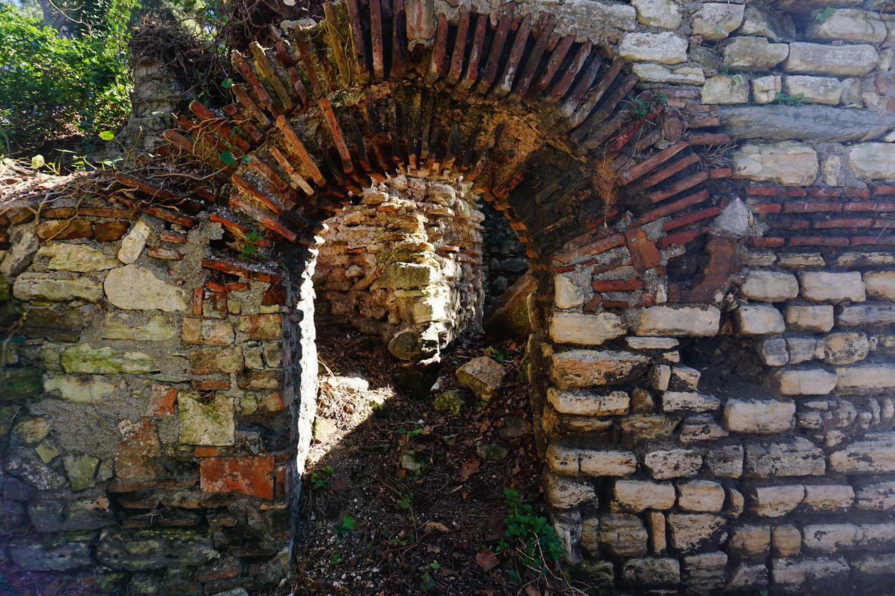 STONE WALL OF OLD BUILDING WITH BRICK WALLS