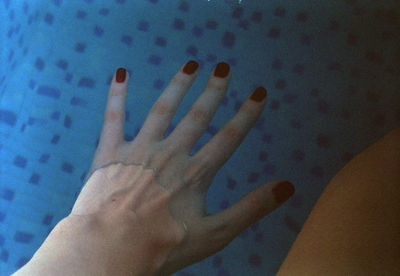 Close-up of human hand against blue background