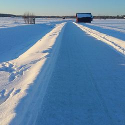 Snow covered landscape against sky