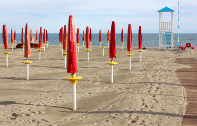 Row of parasols on beach against sky