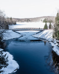 Scenic view of frozen river against sky during winter