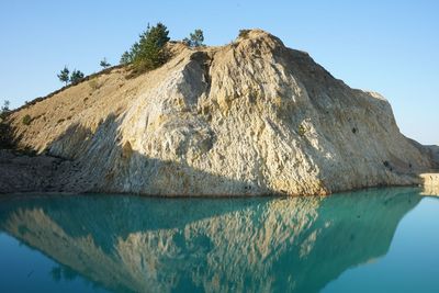 Scenic view of lake and mountains against clear blue sky