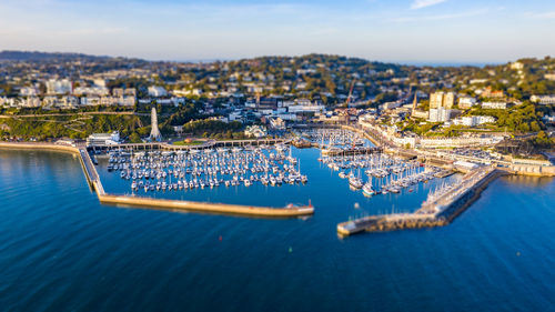 Aerial view of townscape by sea against sky