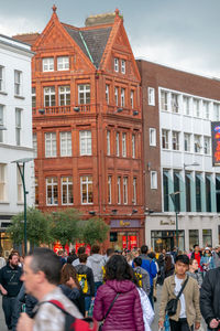 People on street against buildings in city