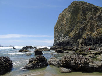 Rocks on sea shore against sky