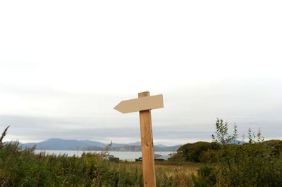 Cross sign on mountain against sky