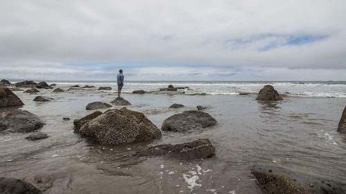 Scenic view of rocks on beach against sky