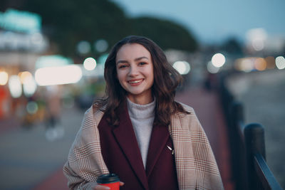 Portrait of smiling young woman standing outdoors