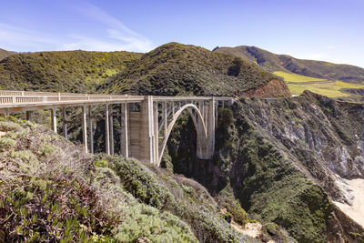 Arch bridge over mountains against sky