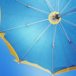 Low angle view of blue parasol against clear sky