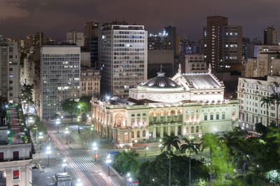 Illuminated cityscape against sky at night