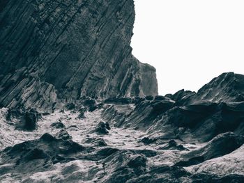 Rock formations in sea against clear sky