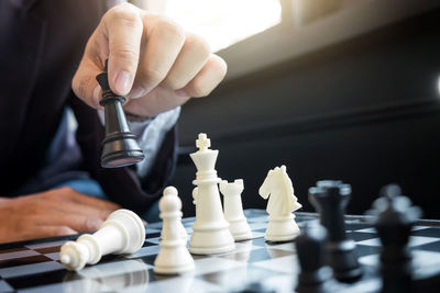 Midsection of businessman playing chess