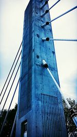 Low angle view of suspension bridge against sky