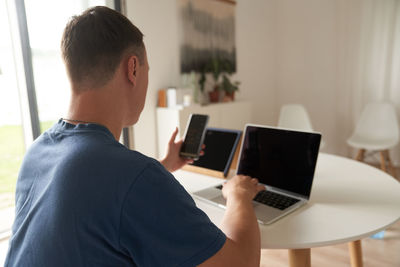 Side view of man using laptop at home