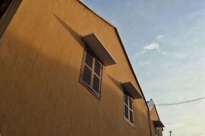 Low angle view of yellow building against sky