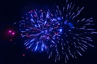 Low angle view of firework display at night