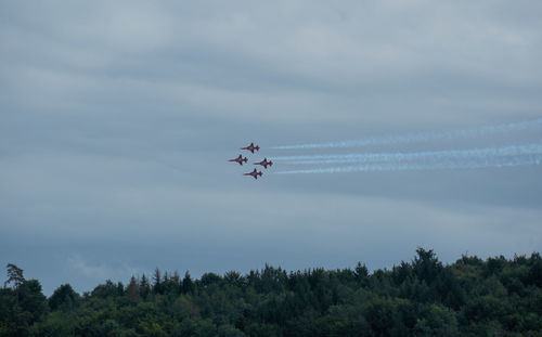 Low angle view of airshow against sky