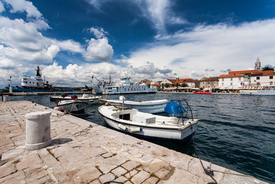 Sailboats moored at harbor