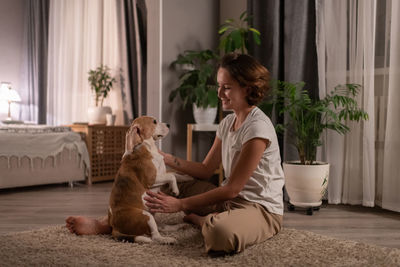 Young woman with dog sitting at home