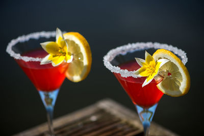 High angle view of drink garnished with yellow flower with lemon slice on wooden table