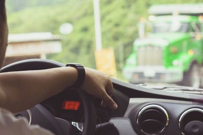 Cropped image of person driving car