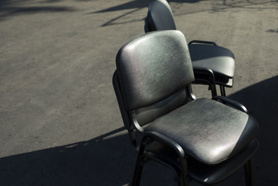 High angle view of empty chair on street during sunny day