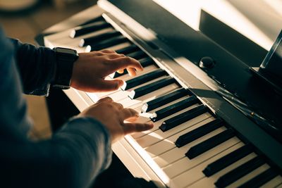 Cropped hand of woman playing piano