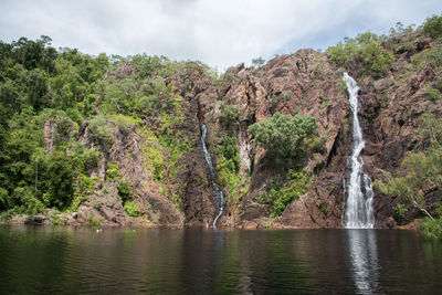 Scenic view of waterfall against sky