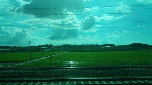 Railroad tracks on field against sky