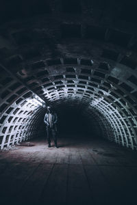 Man wearing hoodie standing in tunnel
