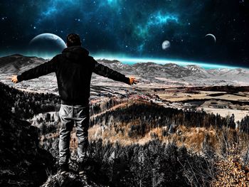 Rear view of man standing on mountain during winter