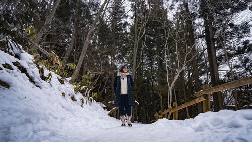 Rear view of woman standing on snow covered landscape