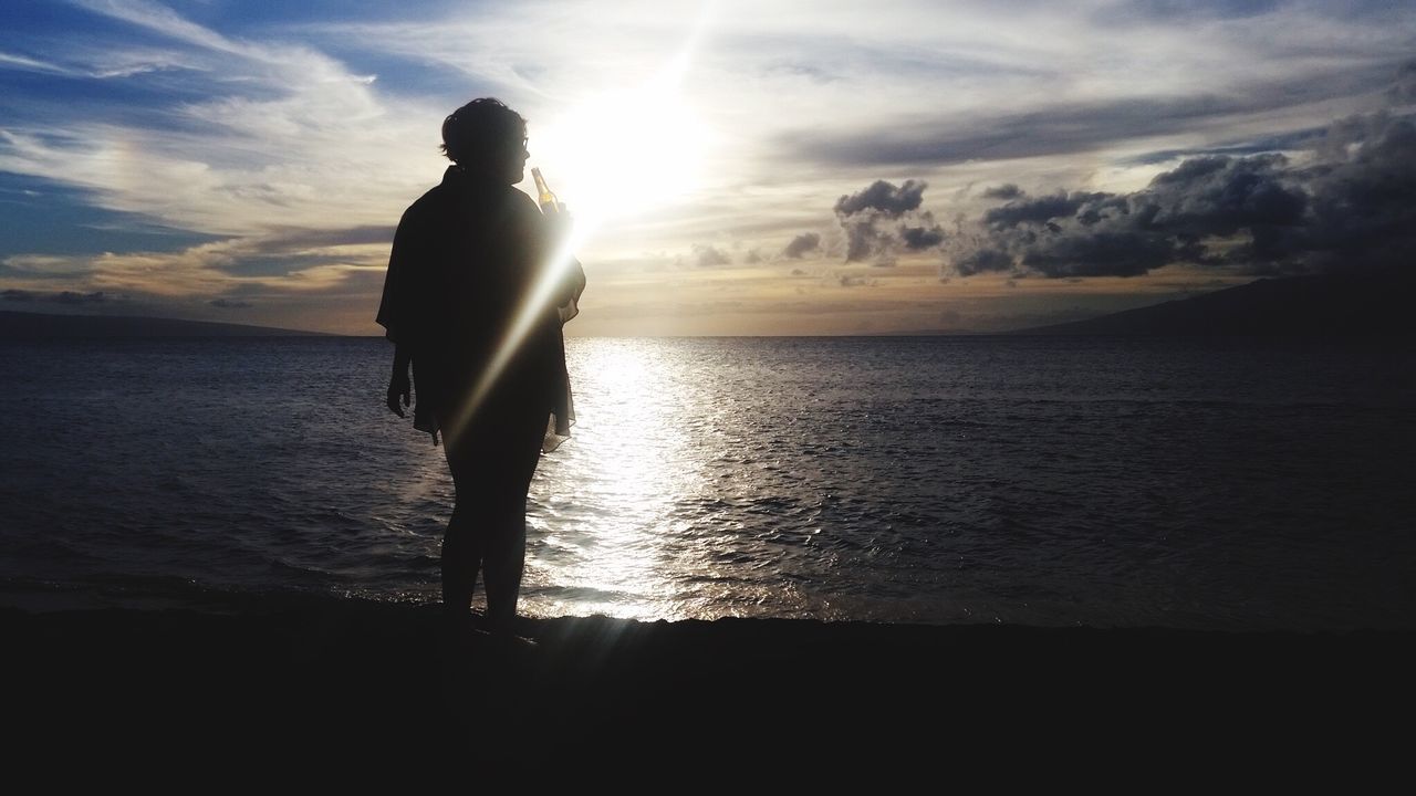 SILHOUETTE OF WOMAN STANDING ON BEACH