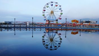 Reflection of ferris wheel in lake