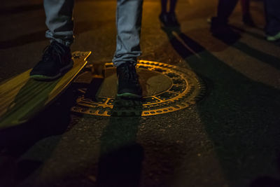 Low section of man on skateboard at night