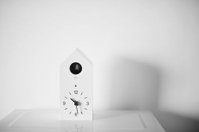 Clock on table against white background