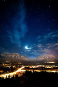 Illuminated cityscape against sky at night