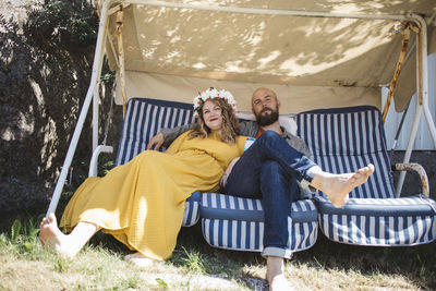 Couple relaxing on garden swing barefoot